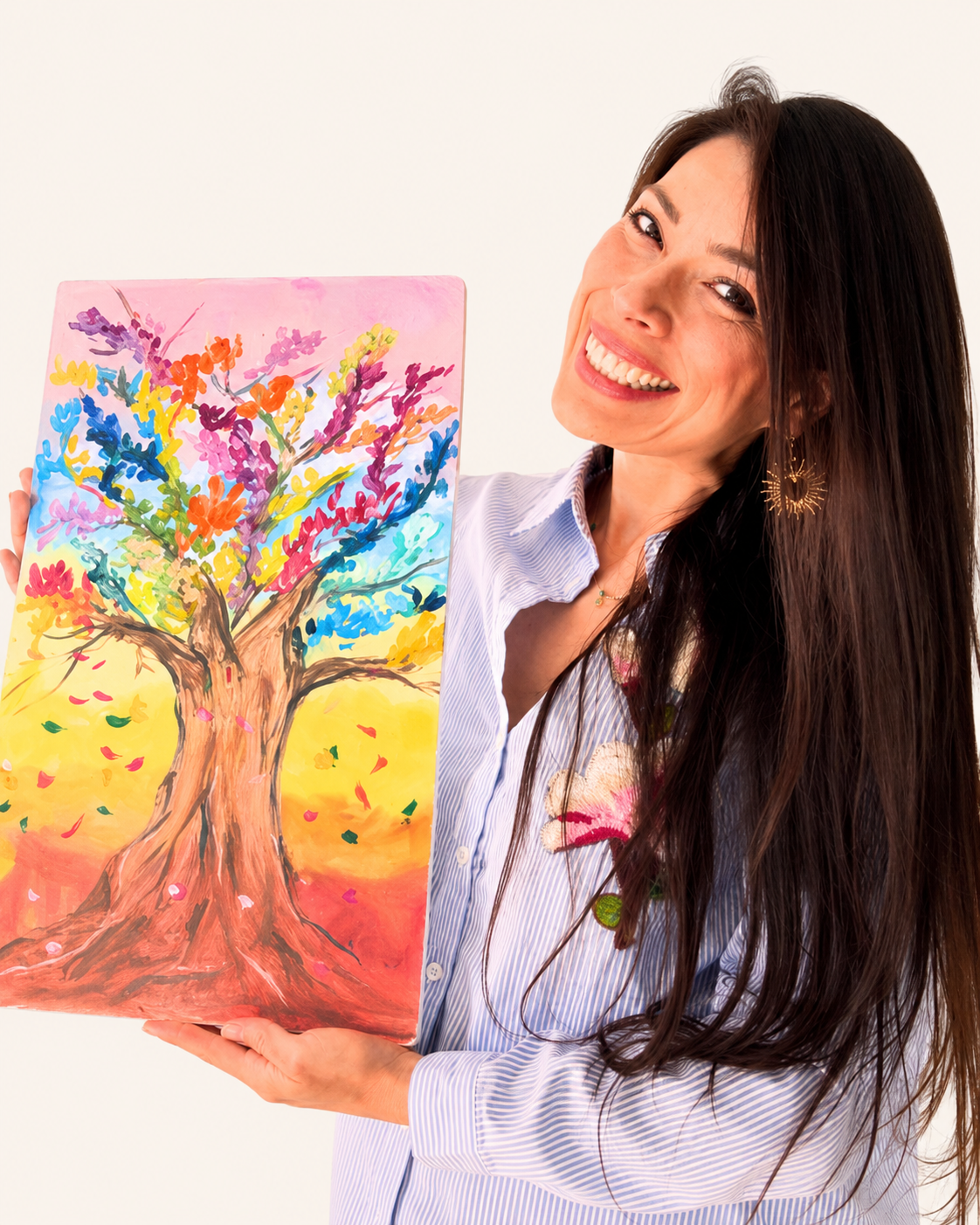 Clau Flores sosteniendo una pintura de un árbol colorido